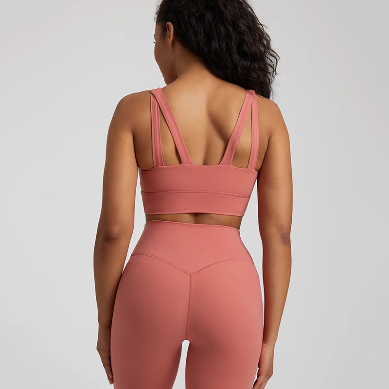 Back view of a woman wearing stylish yoga wear in a pink set, perfect for workouts.